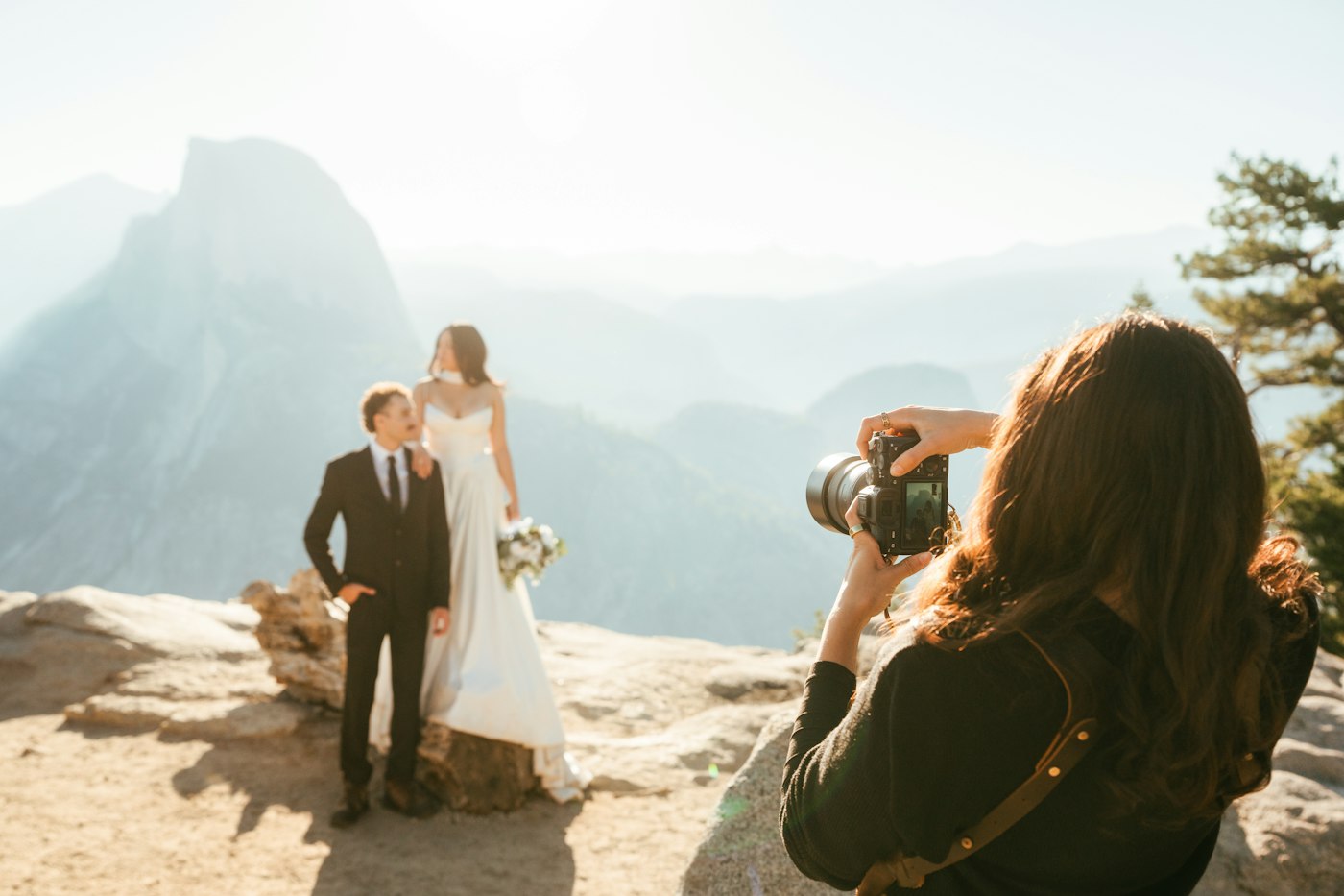 Photographer capturing a bride and groom on a mountain overlook